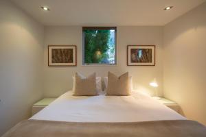 a bedroom with a large white bed with a window at Amaroo in Queenstown