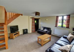 a living room with a couch and a television at Y Stabl in Llandinam