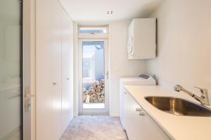 a kitchen with a sink and a door with a window at Amaroo in Queenstown +28 photos