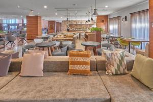 a restaurant with tables and chairs and a couch with pillows at City Express Plus by Marriott Tijuana in Tijuana