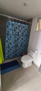 a bathroom with a toilet and a blue shower curtain at Lindo Apartamento en Parque Mateo in Guatemala