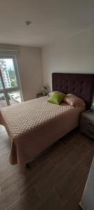 a bedroom with a large bed with a green pillow at Lindo Apartamento en Parque Mateo in Guatemala