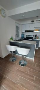 a kitchen with a counter and two stools in it at Lindo Apartamento en Parque Mateo in Guatemala