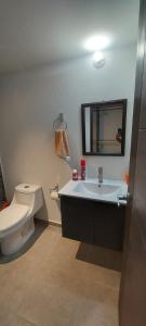 a bathroom with a sink and a toilet and a mirror at Lindo Apartamento en Parque Mateo in Guatemala