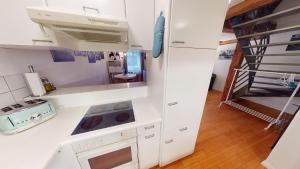 una cocina con armarios blancos y una escalera en Charmante zentrale 2.5 Zimmer Maisonette Wohnung en Chur