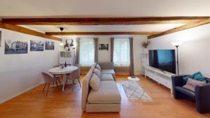 ein Wohnzimmer mit einem Sofa, einem TV und einem Tisch in der Unterkunft Charmante zentrale 2.5 Zimmer Maisonette Wohnung in Chur