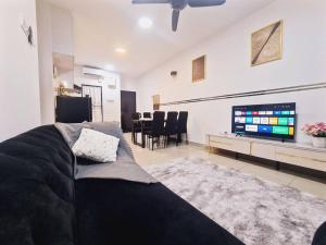 uma sala de estar com um sofá e uma televisão de ecrã plano em New! 4-7pax 2bedrooms condo near Mount Austin JB em Johor Bahru