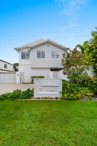 a white house with a fence and a yard at Hamptons by Khove in Gold Coast