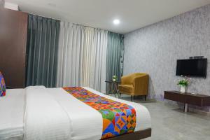a hotel room with a bed and a television at FabHotel Prime Stay Inn in Pune