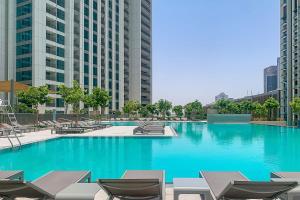 duży basen z krzesłami i niebieską wodą w obiekcie Frank Porter - Downtown Views II T2 w Dubaju