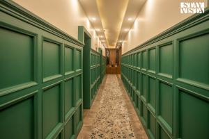 a hallway with green doors and a tile floor at StayVista at Frozen Fall in Gulmarg