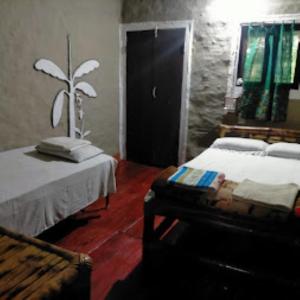 a bedroom with a bed and a chair and a door at Risong Family Guest Gouse Majuli in Majuli