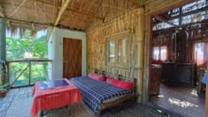 una camera con un letto e un tavolo rosso di Risong Family Guest Gouse Majuli a Majuli