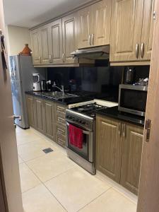 a kitchen with wooden cabinets and a stove top oven at Al badaa in Dubai