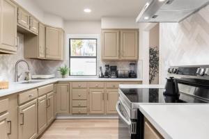 a kitchen with wooden cabinets and a window at Downtown Lodi l Renovated l 5 Bedrooms l Sleeps 10 in Lodi