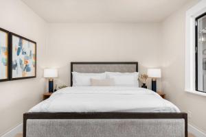 a white bedroom with a large bed with two lamps at Downtown Lodi l Renovated l 5 Bedrooms l Sleeps 10 in Lodi