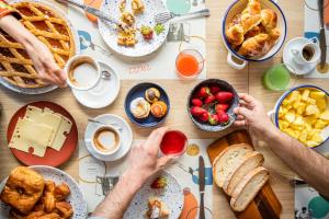 a group of people sitting at a table with breakfast foods at Grand Mercure Sapporo Odori Park in Sapporo