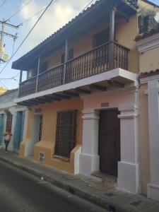 a building with a balcony on the side of a street at Habitaciones Ciudad Amurallada in Cartagena de Indias