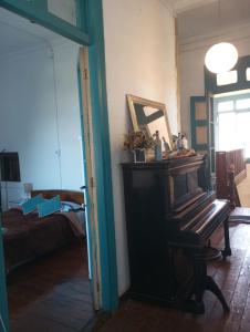 uma sala de estar com um piano e um sofá em República Hostel em Valparaíso