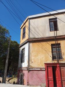 stary budynek z czerwonymi drzwiami na ulicy w obiekcie República Hostel w mieście Valparaíso