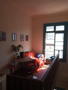 a room with a couch and a table and a window at República Hostel in Valparaíso