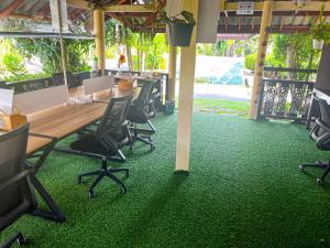 an office with a table and chairs on a green carpet at Amy Village Apartments & Digital Hub in Lamai