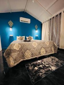LAKSHDEEP COTTAGES في محطة كاناكونا: غرفة نوم بسرير كبير مع بطانية بنية اللون