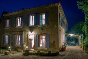 an old house at night with lights on at Relais de l'Alaric in Moux