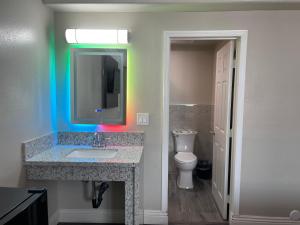 a bathroom with a sink and a mirror and a toilet at Diamond Inn in North Hills