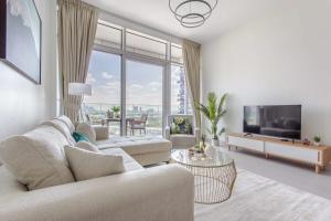 a living room with a couch and a tv at Frank Porter - Park Gate Residences 1 in Dubai