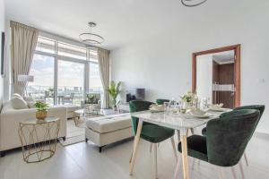 - un salon avec une table, des chaises et un canapé dans l'établissement Frank Porter - Park Gate Residences 1, à Dubaï