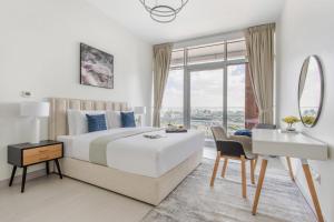 a bedroom with a bed and a desk and a mirror at Frank Porter - Park Gate Residences 1 in Dubai