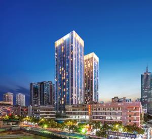 un perfil urbano con rascacielos altos por la noche en Gepai Executive Apartment - Shenzhen Futian Convention and Exhibition Center, en Shenzhen