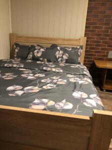 a bed with a blanket with flowers on it at dom polnostju in Krāslava