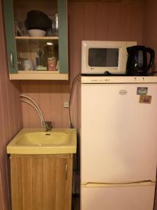 a kitchen with a microwave on top of a refrigerator at dom polnostju in Krāslava