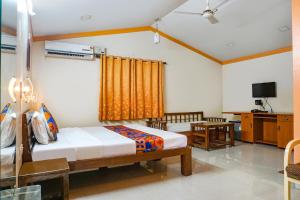 a bedroom with two beds and a television in it at FabHotel Prime Vishwakirti Agri in Ahmadnagar