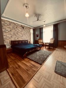 a bedroom with a bed and a brick wall at Shalimar Heights in Srinagar