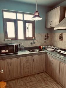 a kitchen with a sink and a microwave at Shalimar Heights in Srinagar