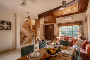 a living room with a table and a couch at Alaya Stays Aravali Woods 4BHK Villa with Mini Movie Theatre in Gurgaon in Gurgaon