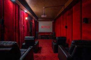 a red room with chairs and a netflix sign at Alaya Stays Aravali Woods 4BHK Villa with Mini Movie Theatre in Gurgaon in Gurgaon