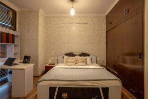 - une chambre avec un grand lit dans l'établissement Alaya Stays Aravali Woods 4BHK Villa with Mini Movie Theatre in Gurgaon, à Gurgaon