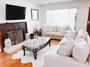 a living room with white furniture and a fireplace at Saikwan Valley Family Home in Milpitas