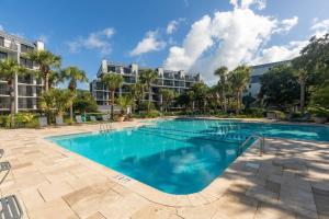 a large swimming pool in front of a building at Shipwatch 418 - Luxury Oceanfront Penthouse in Isle of Palms in Isle of Palms