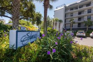 un cartel en un jardín frente a un edificio en Shipwatch 418 - Luxury Oceanfront Penthouse in Isle of Palms, en Isle of Palms