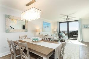 Un comedor y una sala de estar con mesa y sillas. en Shipwatch 418 - Luxury Oceanfront Penthouse in Isle of Palms, en Isle of Palms