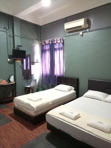 sypialnia z dwoma łóżkami i klimatyzacją na ścianie w obiekcie Rz Gold Hotel Official Account w mieście Kuala Kerai