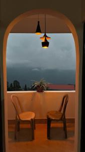 2 chaises et une table devant une fenêtre dans l'établissement The Golden Nest Home Stay , Rongli, à Rongli