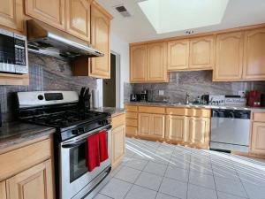 a kitchen with wooden cabinets and a stove top oven at Saikwan Valley Family Home in Milpitas