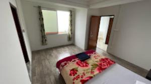 een slaapkamer met een bed met rode bloemen erop bij The Golden Nest Home Stay , Rongli in Rongli