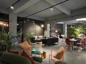 a living room with couches and tables and chairs at 緩慢大鵬灣 in Donggang